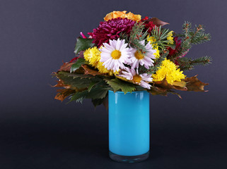 Flower bouquet in blue vase on dark grey background