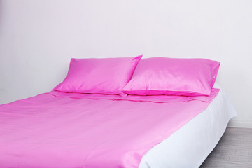 Bed in pink bed linen in room