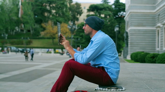Man taking photo by tablet on the public square