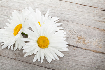 Fototapeta na wymiar Daisy camomile flowers on wooden table
