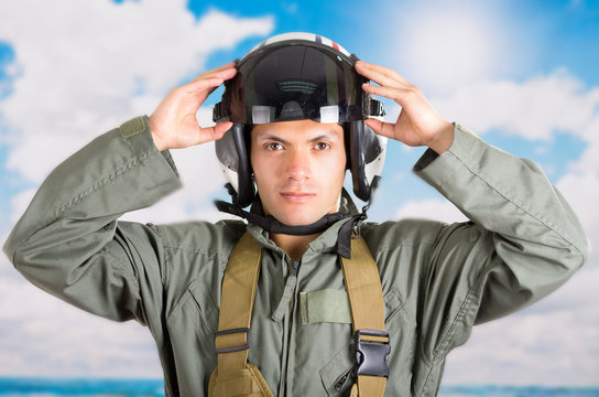 portrait of young pilot wearing helmet with a sky background