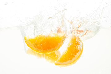 Orange Slices falling deeply under water with a big splash
