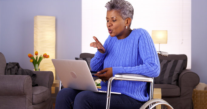 Mature Black woman talking with friend on laptop