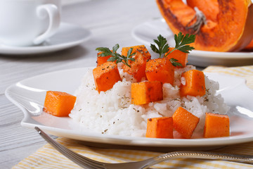 Rice with baked pumpkin and parsley on the plate.