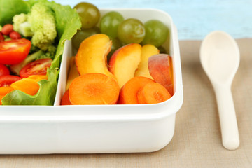 Tasty vegetarian food in plastic box on wooden table