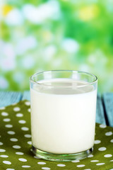 Milk in glass on napkin on natural background