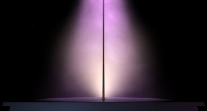 stripper pole on a stage lit by a single spotlight
