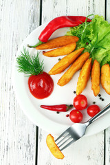 Homemade fried potato on plate on wooden background