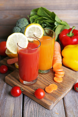 Carrot and tomato juice in glasses and fresh vegetables