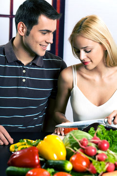 Young attractive happy smiling couple cooking at kitchen
