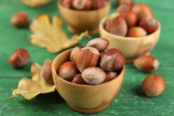 Hazelnuts in wooden bowls on wooden background