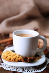 Cup of coffee and tasty cookie on wooden background