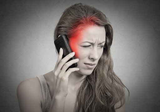 Side profile girl on the phone with headache red area of pain