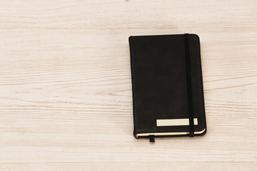 Closed notepad on wooden office desk, top view