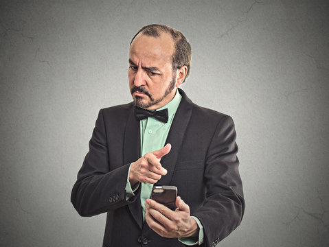 angry middle aged business man looking on mobile phone