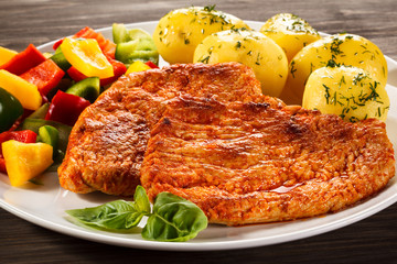 Pork chops, boiled potatoes and vegetables