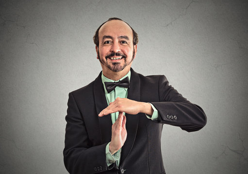 Businessman showing time out sign hand gesture on grey