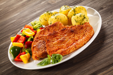 Pork chops, boiled potatoes and vegetables