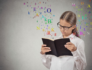 girl reading a book isolated on grey wall background 