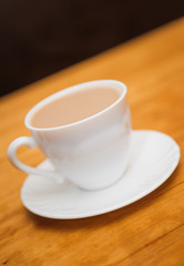 classical white cup of milk coffee on table blur backgrounds