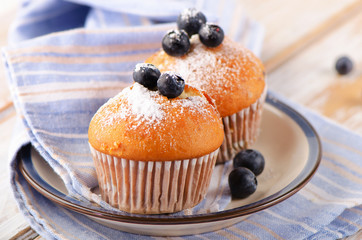 Muffins with fresh blueberries on a  wooden table