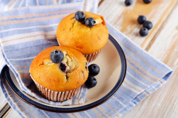 Homemade Muffins with fresh blueberries on a  wooden table