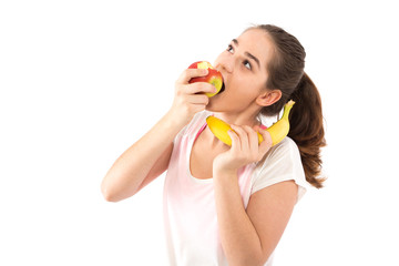 Frau mit Banane beisst in Apfel