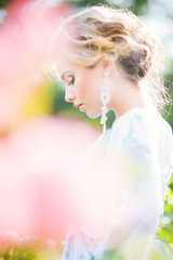 Fototapeta premium beautiful young girl in a garden of flowers