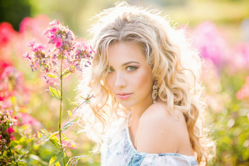 Fototapeta premium beautiful young girl in a garden of flowers