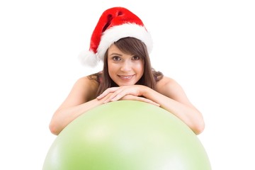 Festive fit brunette leaning on exercise ball