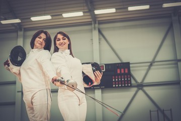 Young woman fencer and her trainer