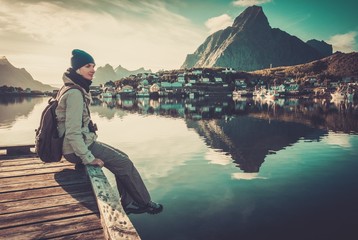 Naklejka premium Woman sitting on a pier in Reine village, Norway