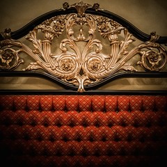 Back of expensive bed with golden ornament