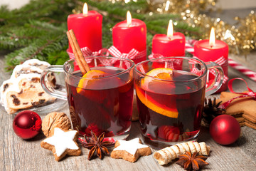 Red mulled wine on table with burning candles