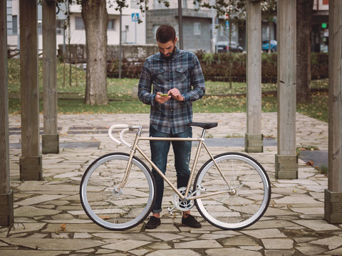 Hipster man with a fixie bike and smartphone