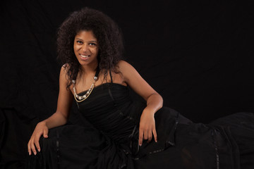 Naklejka premium Black woman reclining and smiling at the camera