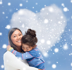 smiling little girl and mother hugging indoors