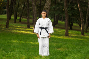 Young woman practicing judo portrait outdoors in a park.