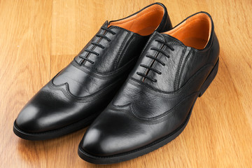 Classic men's shoes stand on the wooden floor
