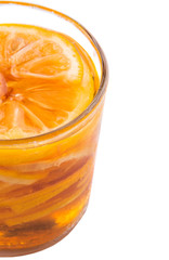 Home remedy of lemon slices and honey in a glass jar over white 