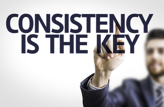 Business man pointing the text: Consistency is The Key