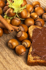 Bread with sweet chocolate hazelnut spread on wooden background