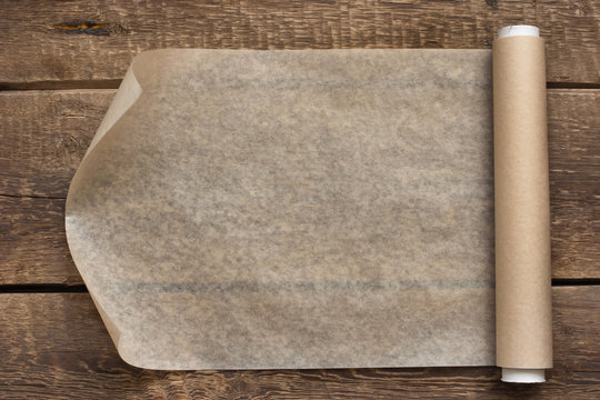 An open roll of paper on the wooden table background