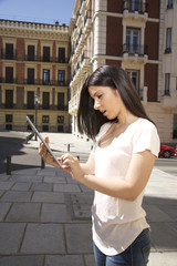 brunette woman with tablet urban background in Madrid city Spain