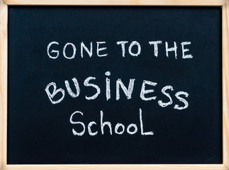 Gone to the business school message written on blackboard