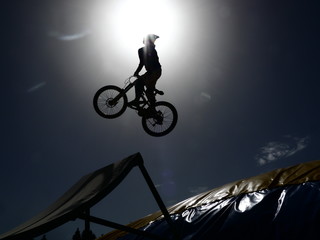 Obraz premium dirtbike bmx rider jumps against sun