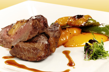 Medium done meat steak served with grilled peppers