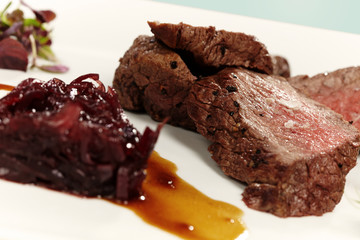 Medium done meat steak served on plate with sweet red onion
