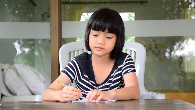 Young girl writing doing homework for school. HD