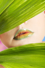 Woman with artistic make up and bamboo leaf